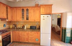 Küche mit Herd, Backofen, Kühlschrank mit Blick ins Wohnzimmer